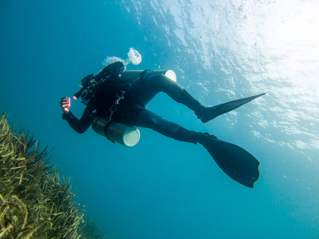 scuba diver with sidemount tanks