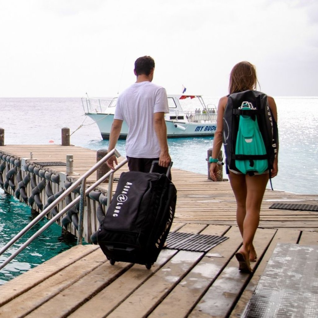 Divers on pier with dive bags